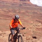 In this photo provided by Cameron Quayle, Nate Malan enjoys riding his bike through red rock country. 