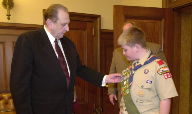 Former LDS Church President Thomas S. Monson looks over merit badges of scout Richard Garff Folkers...