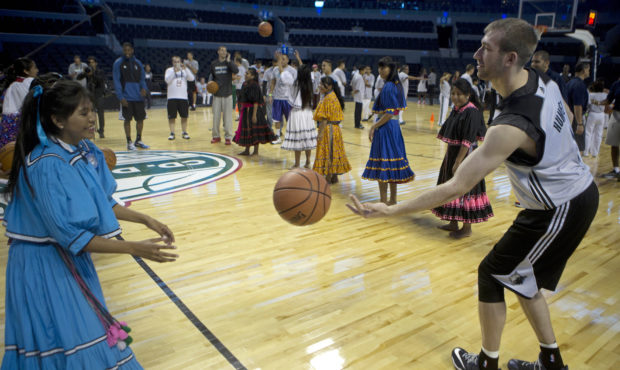 Robbie Hummel of the Minnesota Timberwolves passes the ball to a player from the Tarahumara Indigen...