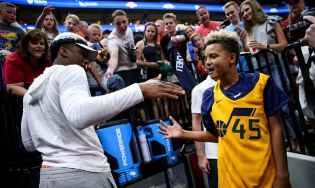 A young fan high-fives Utah Jazz guard Donovan Mitchell after getting his autograph at the end of a...