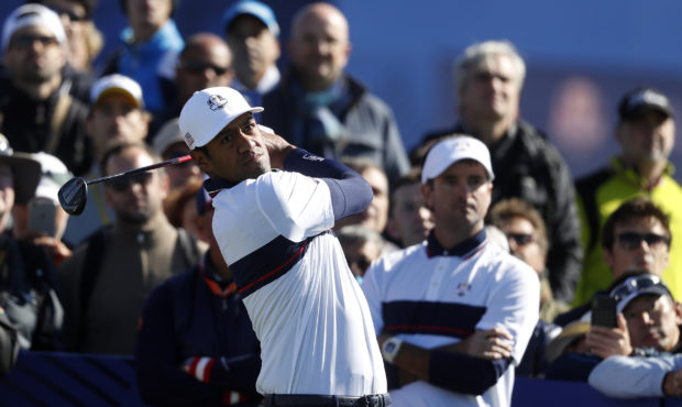 Tony Finau of the US is watched by Bubba Watson of the US as he plays from the 9th tee during a pra...