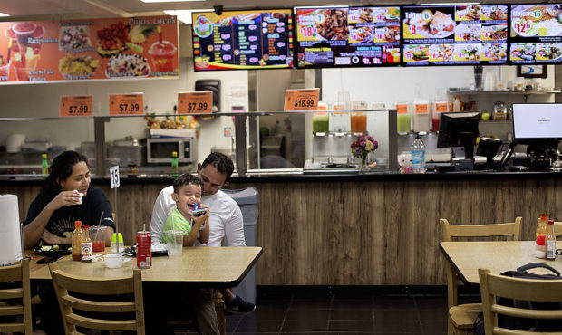 Jennifer Flores and her husband Julio Lopez, and their son, Jadiel, 3, laugh while eating in Rancho...