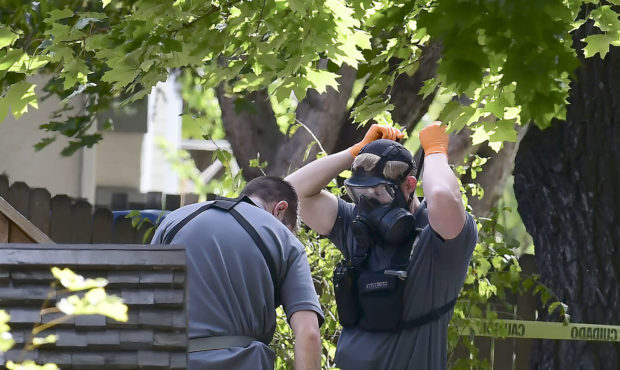 Law enforcement officers search a house on Wednesday, Oct. 3, 2018, in Logan, Utah. A man suspected...
