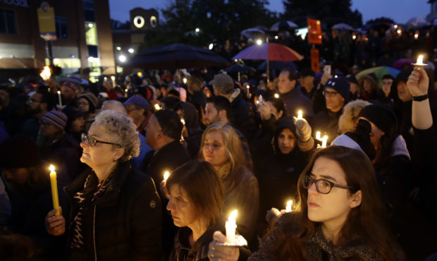 People hold candles as they gather for a vigil in the aftermath of a deadly shooting at the Tree of...
