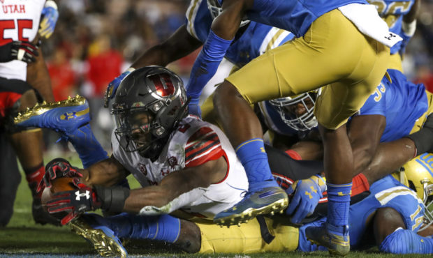Utah Utes running back Zack Moss stretches the ball across the goal line as he lies on top of UCLA ...