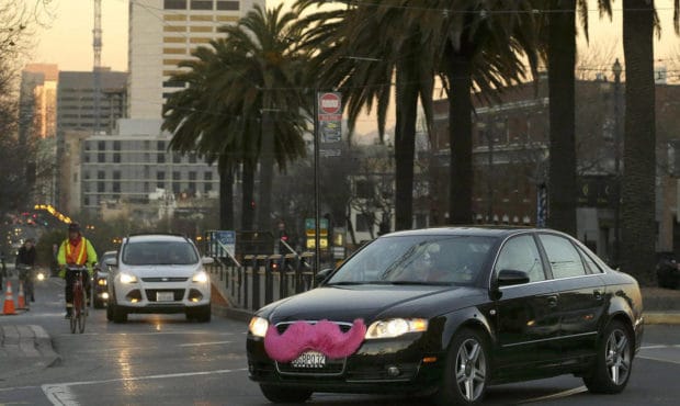 A Lyft car, with the trademark pink mustache, rolls down the streets. (Jeff Chiu, Associated Press)...