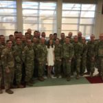 Major Taylor's daughter smiles with members of the Utah National Guard. 