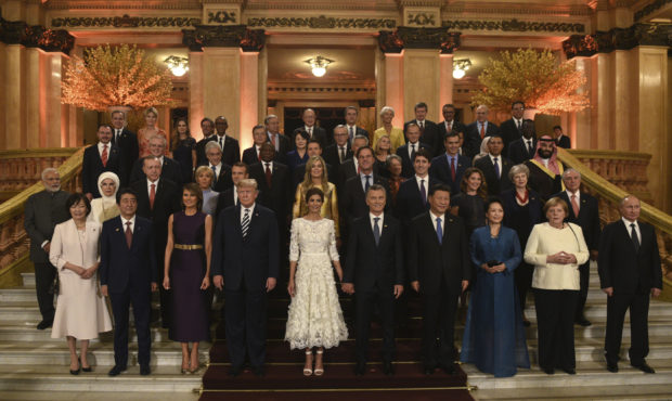 In this photo released by the press office of the G20 Summit, leaders and their partners pose for a...