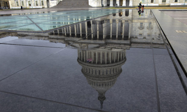 The U.S. Capitol is seen reflected after rain in Washington, Friday, Dec. 21, 2018. The Republican-...