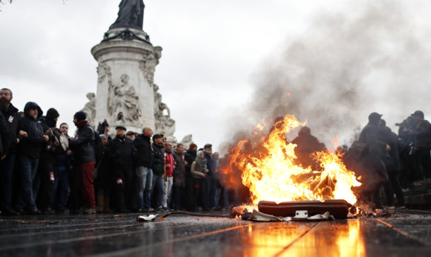 A bin is burning as school children demonstrate in Paris, Friday Dec.7, 2018. Footage showing the b...