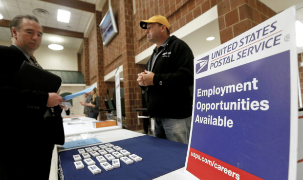 FILE - In this Nov. 2, 2017, file photo a recruiter from the postal service, right, speaks with an ...