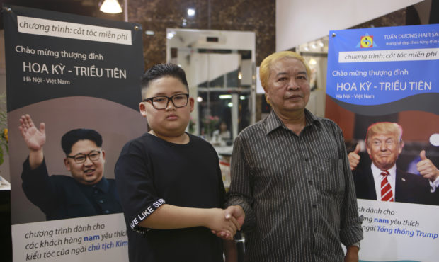Le Phuc Hai, 66 and To Gia Huy, 9, pose for a photo after having Trump and Kim haircuts in Hanoi, V...