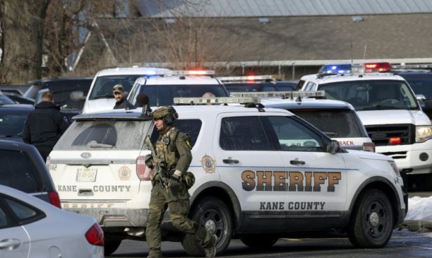 Law enforcement personnel gather near the scene where an active shooter was reported in Aurora, Ill...