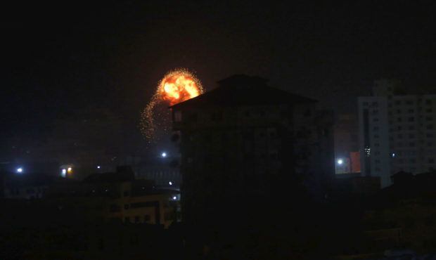 An explosion caused by Israeli airstrikes is seen on Gaza City, early Friday, Friday, March 15, 201...