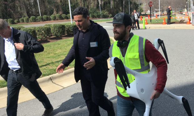 Matternet CEO Andreas Raptopoulos walks next to an operator carrying a drone used for delivery of m...