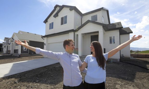 In this April 27, 2019, photo, Andy and Stacie Proctor stand in front of their new home in Vineyard...