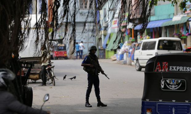 A Sri Lankan naval soldier stands guard at a road leading to a closed market on May Day in Colombo,...