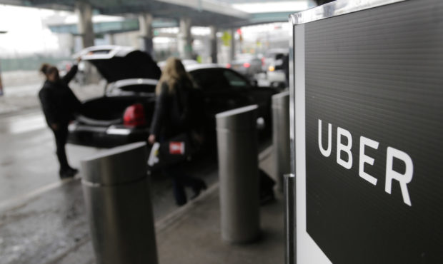FILE - In this March 15, 2017, file photo, a sign marks a pick-up point for the Uber car service at...