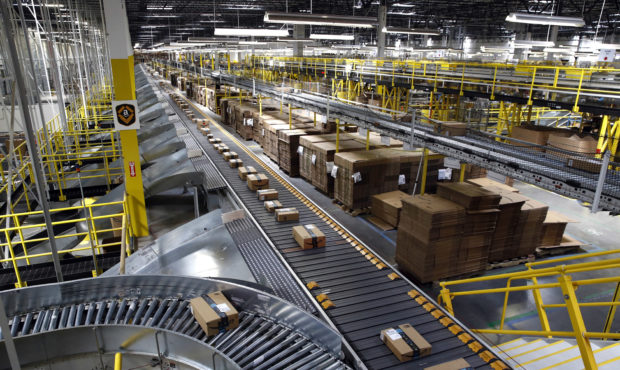 FILE- In this Aug. 3, 2017, file photo, packages ride on a conveyor system at an Amazon fulfillment...
