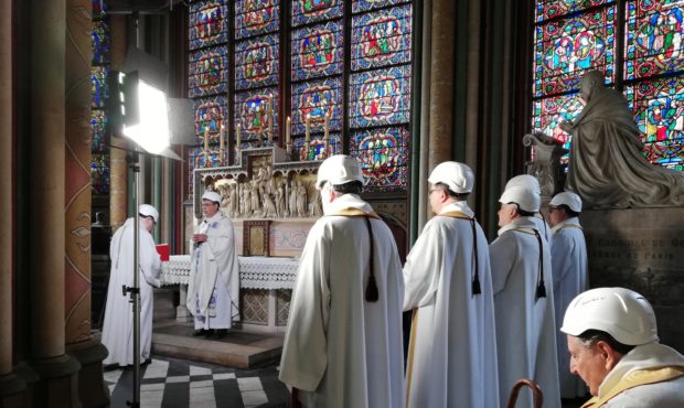 The Archbishop of Paris Michel Aupetit, second left, leads the first mass in a side chapel, two mon...