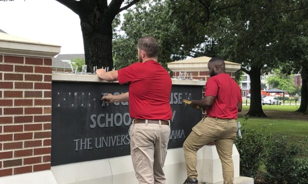 University of Alabama employees remove the name of Hugh F. Culverhouse Jr. off the School of Law si...