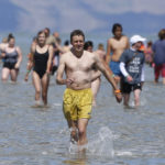 People come out of the Great Salt Lake during a gathering that fell short of making it into the record books Saturday, June 8, 2019, near Magna, Utah. Utah park officials invited people to a beach on the lake's south end in an attempt to set the world record for the largest number of people floating together, unassisted, in a line at one time. Utah State Parks manager Jim Wells said only about 300 people showed up for the event. According to the Guinness World Records website , Argentina holds the current record after 1,941 people successfully floated together on the surface of Lago Epecuén de Carhué in 2017. (AP Photo/Rick Bowmer)