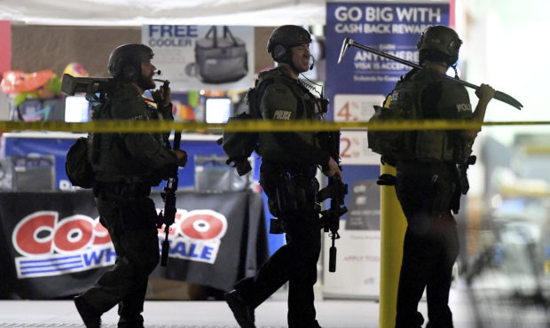 Heavily armed police officers exit the Costco following a shooting inside the wholesale warehouse i...