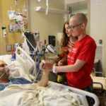 Chloe Robinson (right) visits her dad Scott Robinson (left) while he recuperates in the burn unit of the University of Utah Hospital. (Courtesy of Marta Dansie)