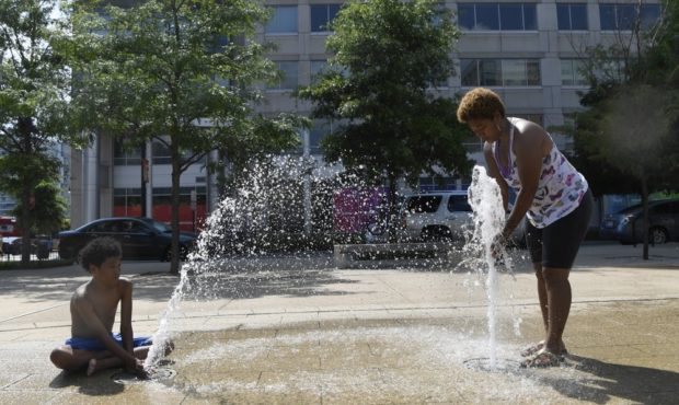 Karen Frazier of Capitol Heights, Md., right, and her son Amari Rogers, 11, left, play in a fountai...