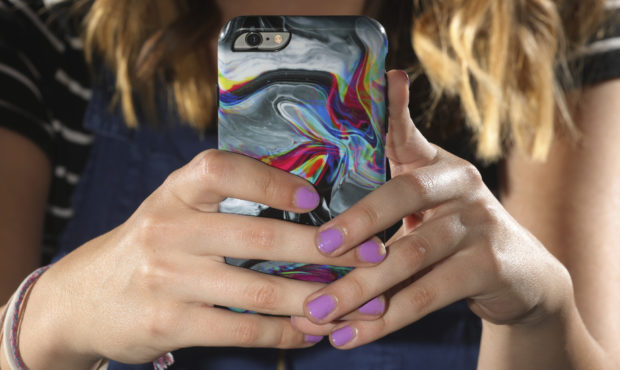 FILE: In this Monday, July 22, 2019, photo, Rachel Whalen looks at her phone at her home in Draper,...