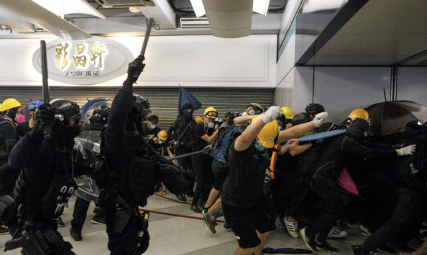 Special Tactical Squad officers attack protesters with batons who refused to disperse from a train ...