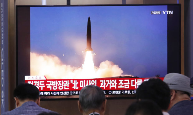 People watch a TV showing a file image of North Korea's missile launch during a news program at the...