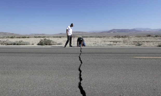 Ron Mikulaco, right, and his nephew, Brad Fernandez, examine a crack caused by an earthquake on Hig...