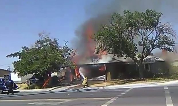 In this image taken from video provided by Ben Hood, a firefighter works to extinguish a fire, Thur...