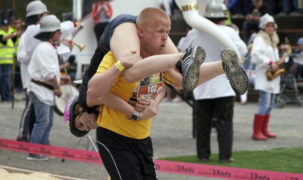 People take part in the wife carrying race, a 278-yard obstacle course, during the 24th world champ...