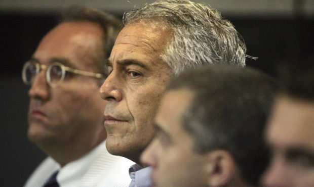 FILE - In this July 30, 2008 file photo, Jeffrey Epstein, center, is shown in custody in West Palm ...