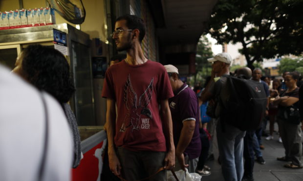 People walk in the streets of Caracas after a massive blackout left the city and other parts of the...