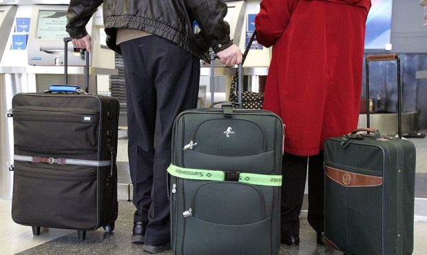 File - Travelers with their luggage (Photo by Tim Boyle/Getty Images)...