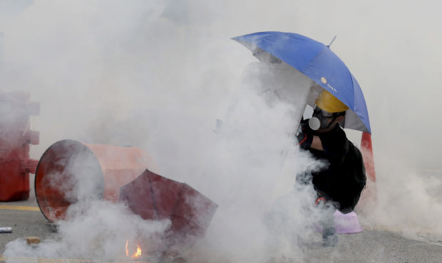 A protester is shrouded by tear gas in Hong Kong, Monday, Aug. 5, 2019. Droves of protesters filled...