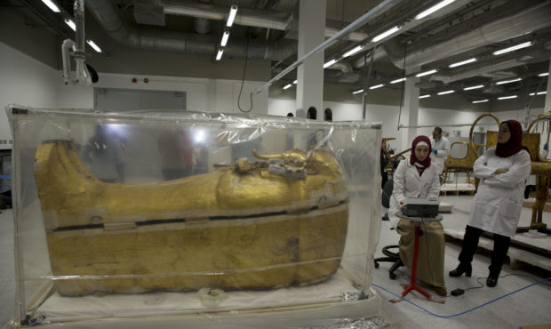 The gold-covered sarcophagus of King Tutankhamun is encased in a tent for restoration procedures at...