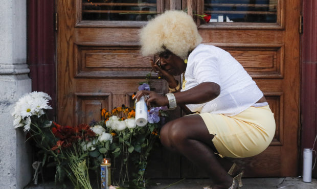 In this Aug. 4, 2019 photo Annette Gibson Strong places candles at a makeshift memorial for the sla...