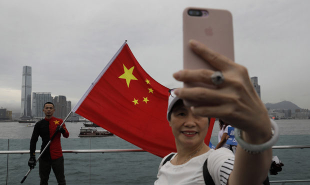 In this Saturday, Aug. 17, 2019 file photo, pro-China supporters take a selfie with a Chinese natio...