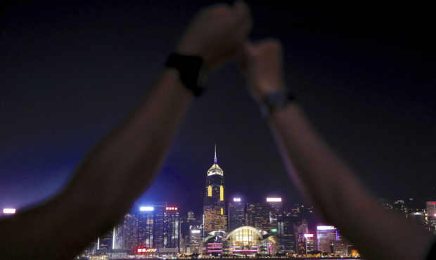 Demonstrators link hands as they gather at the Tsim Sha Tsui waterfront in Hong Kong, Friday, Aug. ...