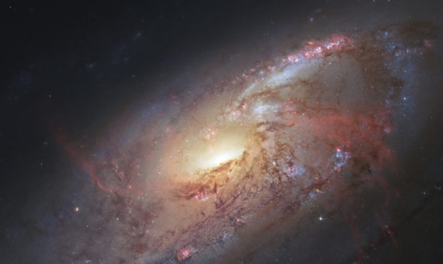 FILE - This file image made by the NASA/ESA Hubble Space Telescope shows M106 with additional infor...