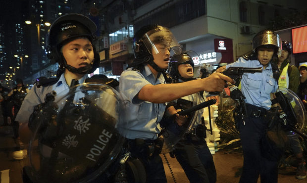 Policemen pull out their guns after a confrontation with demonstrators during a protest in Hong Kon...