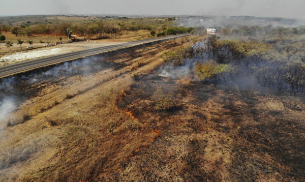 Fire consumes a field along the BR 070 highway near Cuiaba, Mato Grosso state, Brazil, Sunday, Aug....