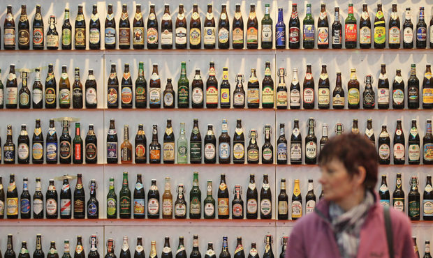 FILE - A woman walks among hundreds of bottles of German beer, meant to represent the approximately...