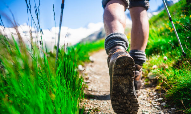 Hiker on mountain trail, Close-up. Photo courtesy of Getty Images....