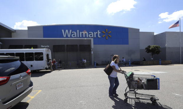 A customer pushes a shopping cart Tuesday, Sept. 3, 2019, outside a Walmart store, in Walpole, Mass...