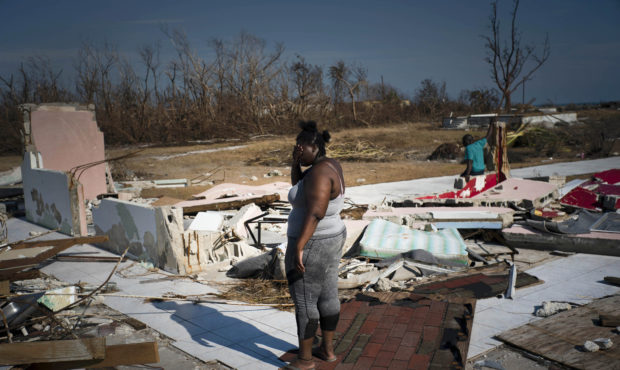 A woman is overcome as she looks at her house destroyed by Hurricane Dorian, in High Rock, Grand Ba...